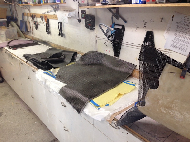 Many yards of fiberglass, kevlar and carbon fiber cut in preparation for layup